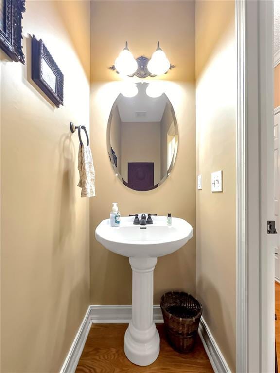 bathroom with baseboards and wood finished floors