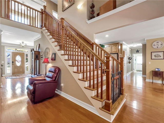 stairs featuring baseboards, wood finished floors, and crown molding