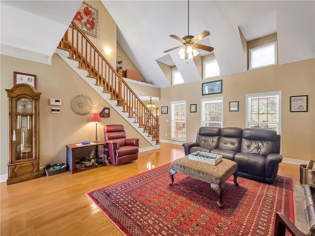 living room with wood finished floors, ceiling fan, baseboards, and stairs