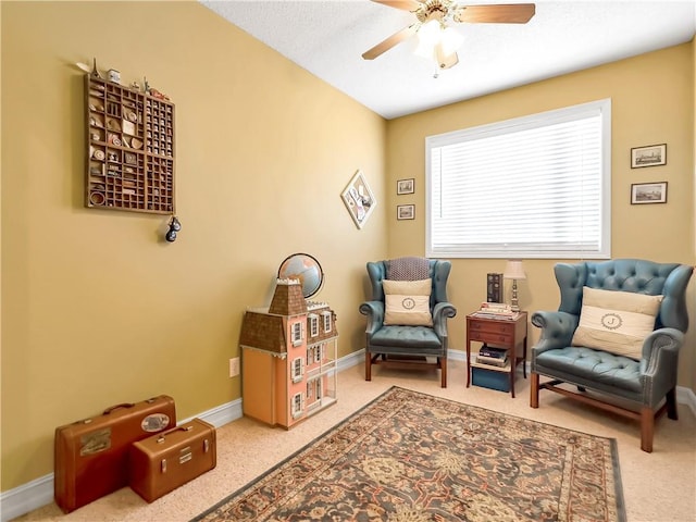 living area with carpet floors, a ceiling fan, and baseboards