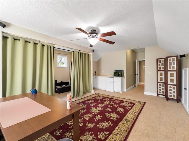 home office with lofted ceiling, a textured ceiling, and light colored carpet