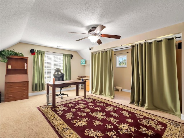 office space with vaulted ceiling, a healthy amount of sunlight, and light colored carpet