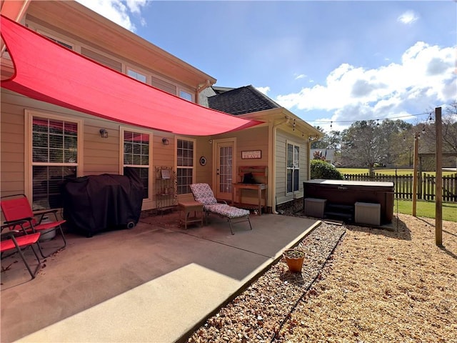 view of patio / terrace featuring a hot tub, fence, and area for grilling