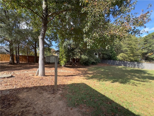 view of yard featuring an outbuilding, a storage shed, and a fenced backyard