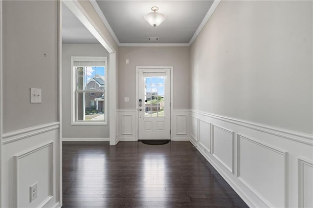 foyer entrance with dark wood-style flooring, visible vents, crown molding, wainscoting, and a decorative wall