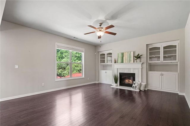 unfurnished living room with baseboards, visible vents, a ceiling fan, and dark wood-type flooring