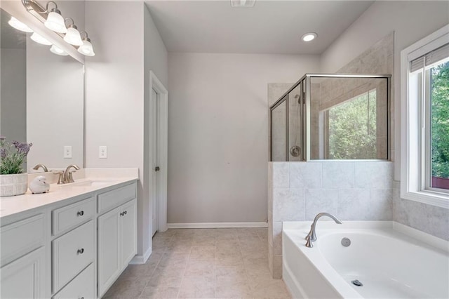 bathroom with a bath, a shower stall, vanity, baseboards, and recessed lighting