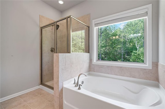 full bath with baseboards, tile patterned flooring, a garden tub, and a stall shower