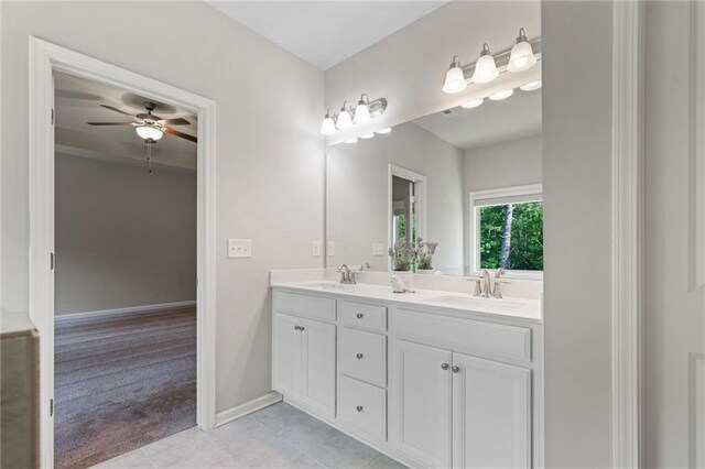 full bath with double vanity, baseboards, ceiling fan, tile patterned floors, and a sink
