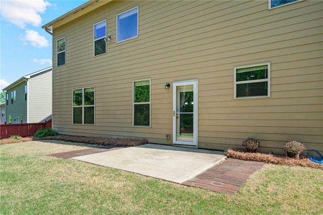 rear view of property with a patio, fence, and a yard