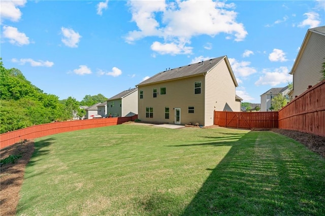 back of house with a yard, a fenced backyard, and a patio area