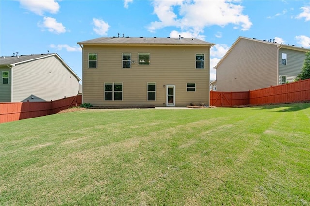rear view of property with a lawn and a fenced backyard
