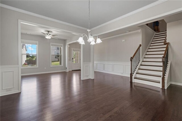 interior space with stairway, ornamental molding, ceiling fan with notable chandelier, and dark wood finished floors