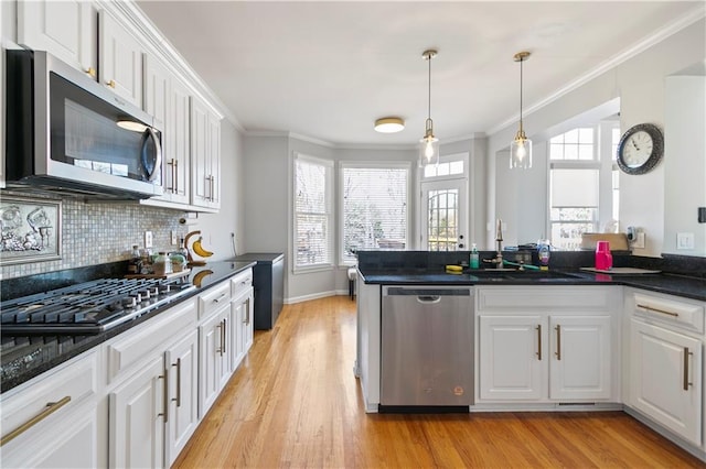 325 Stonecastle Pass, South Fulton, GA 30331 - kitchen with crown molding, light wood finished floors, stainless steel appliances, dark countertops, and white cabinets