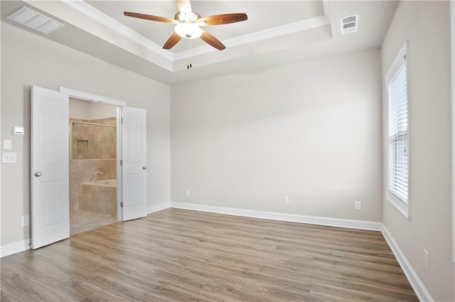 3657 Atherton Park Ct, Suwanee, GA 30024 - unfurnished bedroom with a raised ceiling, multiple windows, wood finished floors, and connected bathroom