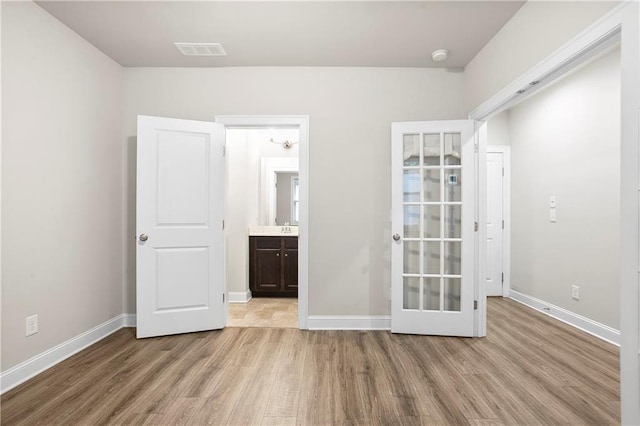 3657 Atherton Park Ct, Suwanee, GA 30024 - unfurnished bedroom with wood finished floors, french doors, and ensuite bathroom