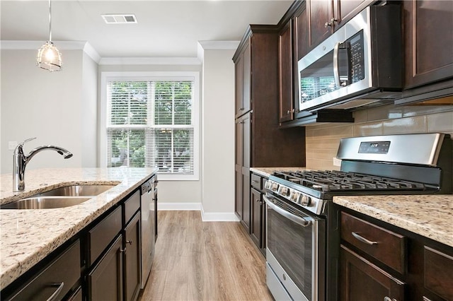 3657 Atherton Park Ct, Suwanee, GA 30024 - kitchen featuring appliances with stainless steel finishes, crown molding, dark brown cabinets, light wood-style floors, and backsplash