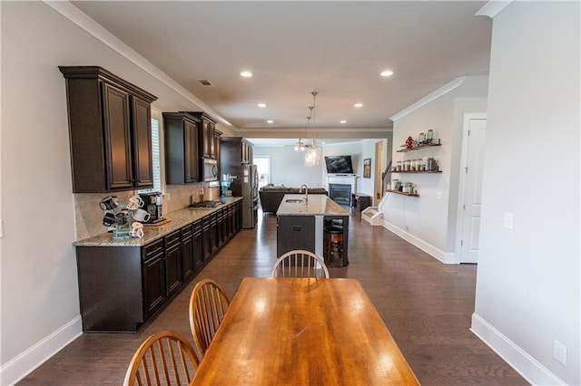 6390 Yellow Birch St, Cumming, GA 30040 - kitchen with appliances with stainless steel finishes, dark brown cabinets, open floor plan, a center island with sink, and a sink