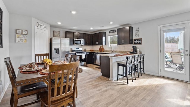 dining space with a wealth of natural light and light hardwood / wood-style flooring