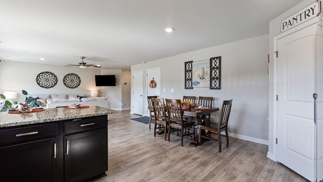 dining room with light hardwood / wood-style floors and ceiling fan