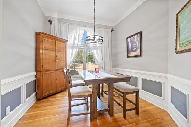 19 Spring Lake Trl NE, White, GA 30184 - dining space featuring a chandelier, crown molding, a decorative wall, light wood-style flooring, and a wainscoted wall