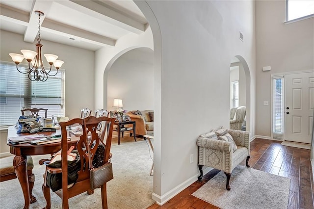 dining area with arched walkways, beamed ceiling, visible vents, and a healthy amount of sunlight