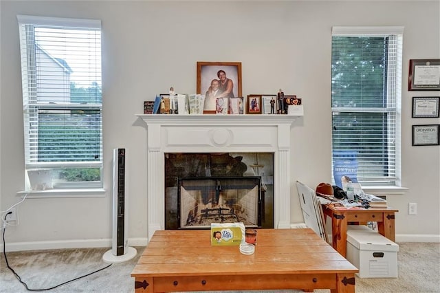 living area with a tiled fireplace and baseboards