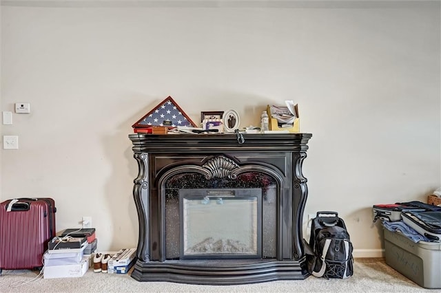 room details featuring a glass covered fireplace and carpet flooring