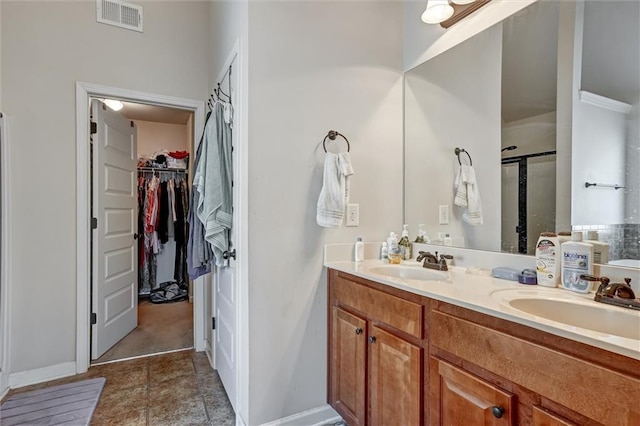 full bathroom with double vanity, a stall shower, a sink, and visible vents