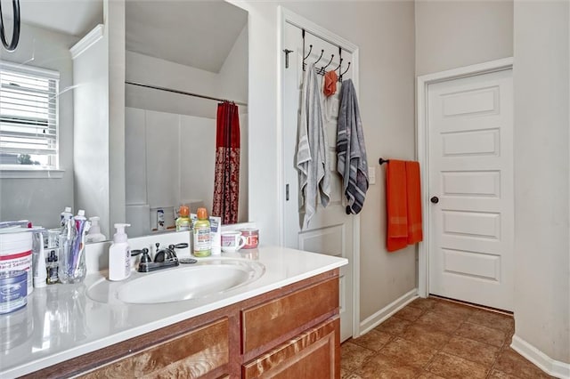 bathroom with curtained shower, tile patterned flooring, vanity, and baseboards