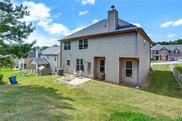 rear view of property with an outbuilding, a yard, a chimney, a storage shed, and a patio area