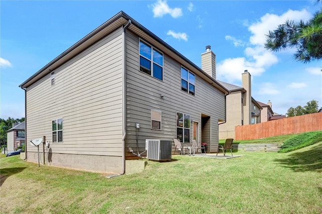 rear view of property with a yard, a patio area, cooling unit, and fence