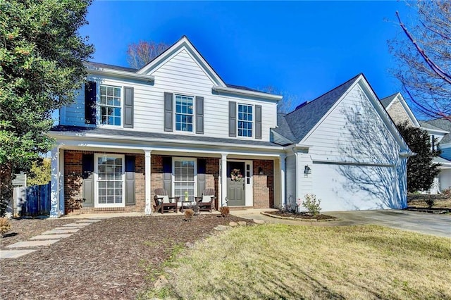 view of front of home featuring a porch, an attached garage, brick siding, driveway, and a front yard