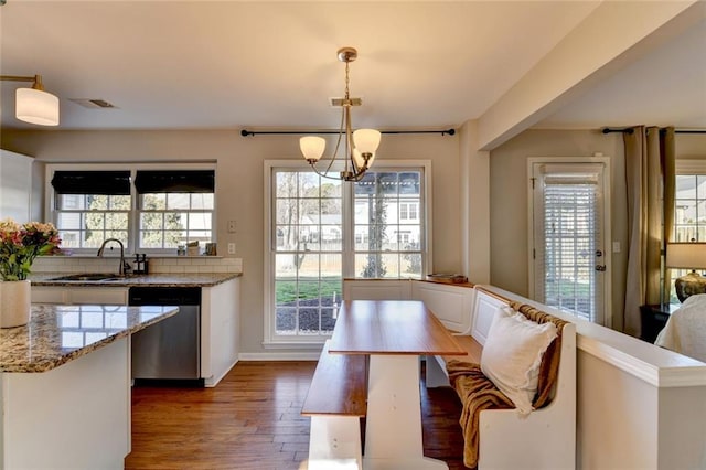 dining room with a notable chandelier, wood finished floors, visible vents, and a healthy amount of sunlight