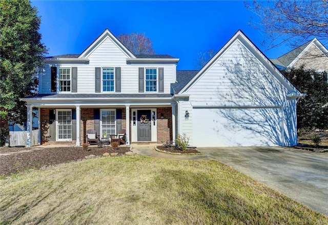 view of front of home featuring brick siding, covered porch, a front yard, a garage, and driveway