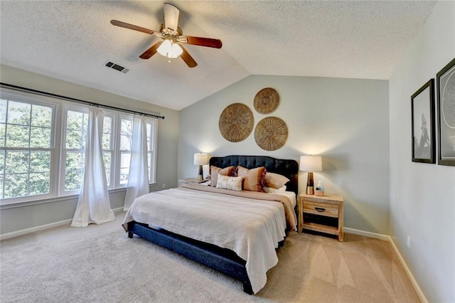 carpeted bedroom with lofted ceiling, visible vents, a ceiling fan, a textured ceiling, and baseboards