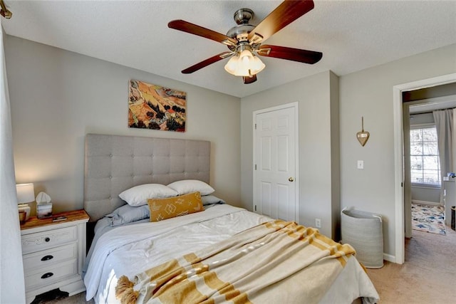 bedroom with light carpet, ceiling fan, and baseboards