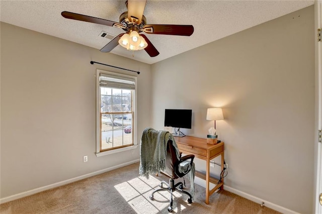 carpeted home office featuring a ceiling fan, visible vents, a textured ceiling, and baseboards