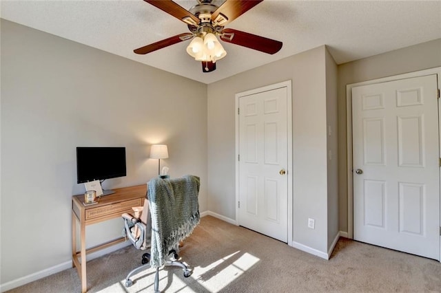 office space with a ceiling fan, carpet, and baseboards