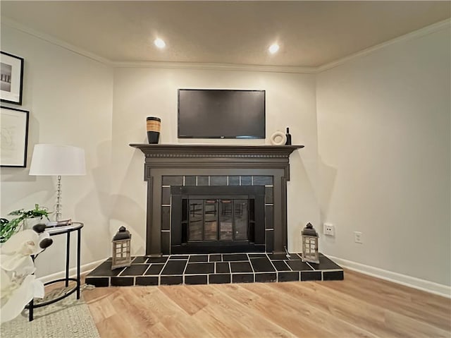 living area featuring crown molding, a fireplace, and wood finished floors