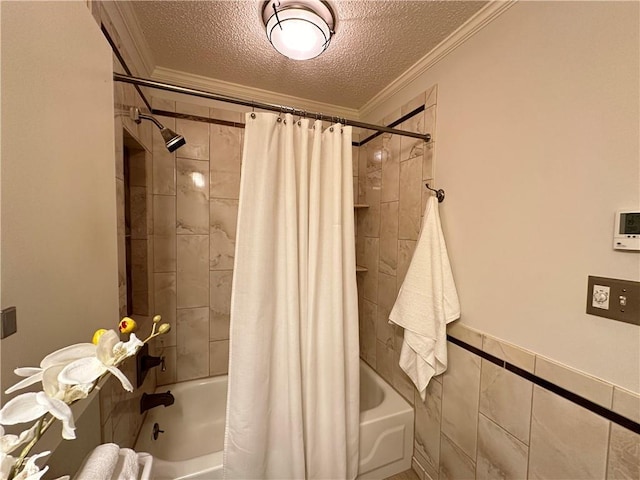 bathroom featuring tile walls, shower / bathtub combination with curtain, ornamental molding, and a textured ceiling