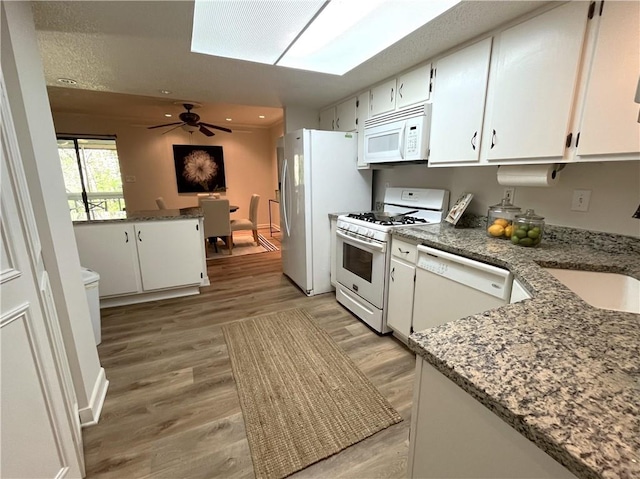 kitchen with light wood-type flooring, white appliances, ceiling fan, and white cabinets