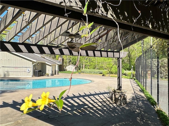 pool featuring an outbuilding, a storage unit, a patio area, fence, and a pergola