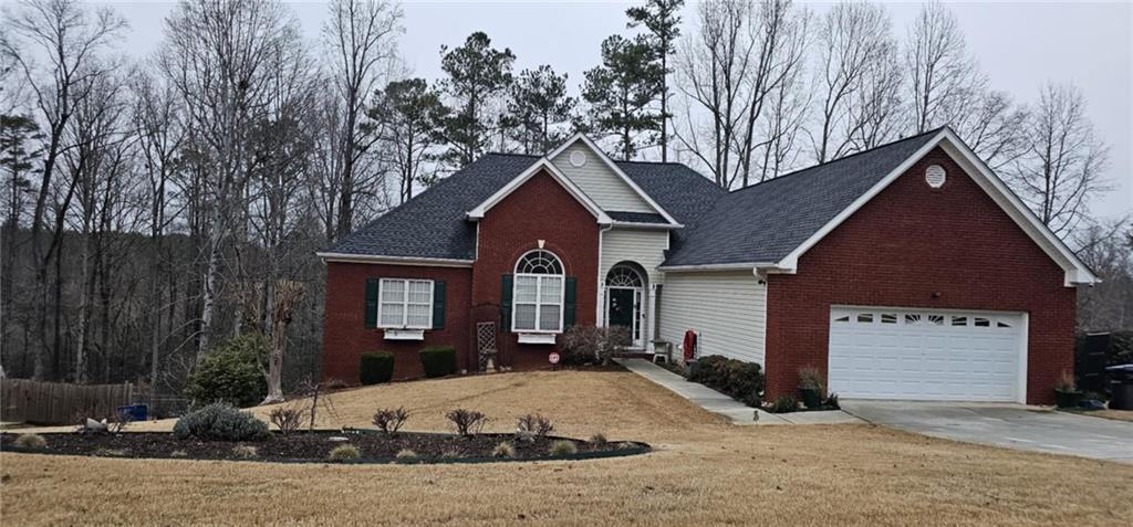 70 Trelawney Cir, Covington, GA 30016 - traditional home with a front yard, brick siding, and driveway