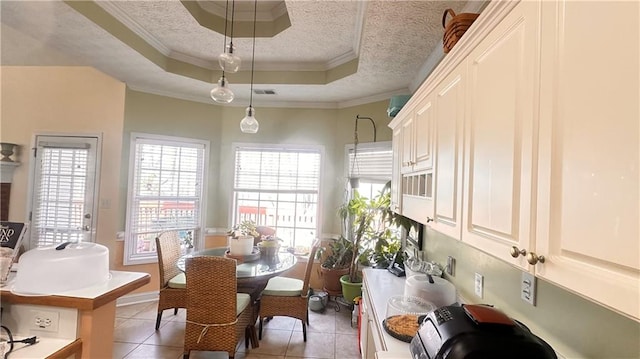 dining space with a raised ceiling, ornamental molding, visible vents, and a textured ceiling