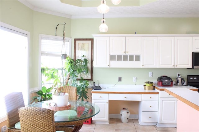 kitchen with pendant lighting, white cabinetry, light countertops, and ornamental molding