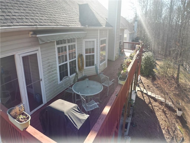 wooden terrace featuring grilling area and outdoor dining space