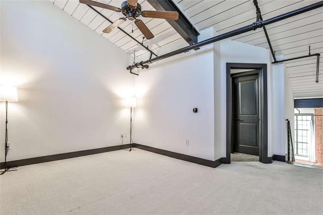 unfurnished room featuring carpet floors, vaulted ceiling with beams, ceiling fan, and baseboards