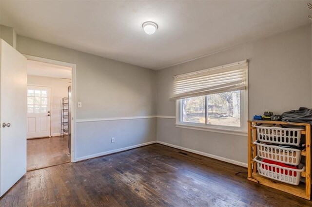 unfurnished bedroom with dark hardwood / wood-style floors and multiple windows