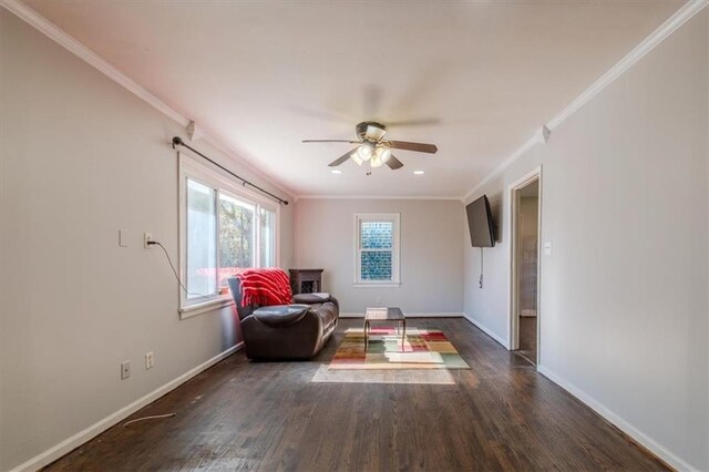 living area featuring ceiling fan, crown molding, and dark wood-type flooring